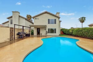 Rear view of 5003 W Wikieup Lane with curved pool and wide pool deck