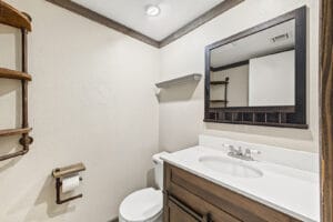 Half bath with wood vanity, white countertop and rustic pipe shelving