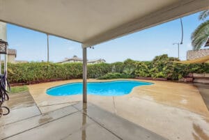 View from the covered patio to the pool and landscaped backyard in Glendale, AZ