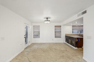 Dining area with stained concrete floors and patio door, open to the kitchen