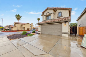 Street view of 5003 W Wikieup Lane with wide driveway and palm trees