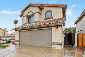 Front of a Glendale home with side gate, tile roof and two-car garage
