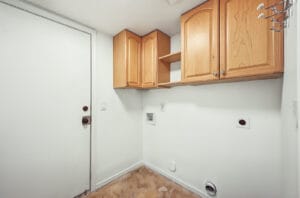 Laundry room with maple upper cabinets and washer and dryer hookups