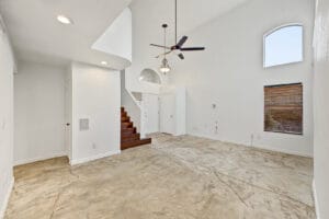 Living room with soaring ceilings, arched windows and wood staircase in a Glendale, AZ home
