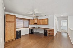 Upstairs loft with built-in desk, wood cabinets and wood-look flooring