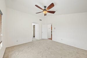 Primary bedroom with vaulted ceiling, ceiling fan and walk-in closet
