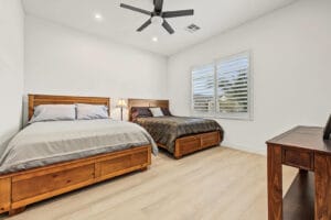 Second bedroom with wood-look vinyl plank flooring and plantation shutters