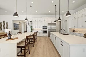 White cabinetry with matte black hardware and brick-style backsplash