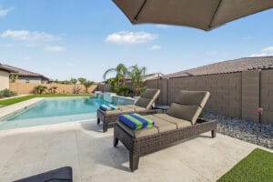 Pool deck surrounding the heated pool, with palms and desert landscaping