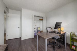 Bedroom with closet open to show wire shelving and storage space