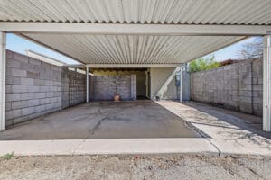 Double covered carport with block side walls leading to the back patio entrance