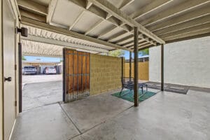 Covered patio with gate opened to the rear carport and alley parking area