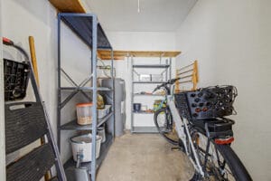 Exterior storage room with metal shelving, concrete floor, and water heater