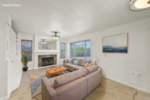 Virtually staged family room with sectional sofa facing a tile-surround fireplace
