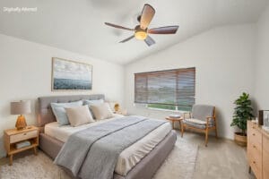 Virtually staged bedroom with vaulted ceiling, upholstered bed and reading chair