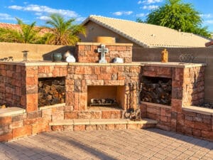 Stone wood-burning outdoor fireplace with built-in firewood storage nooks on each side