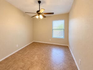 Secondary bedroom with ceiling fan, tile flooring and window with blinds